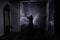 Horror silhouette of ghost inside dark room with mirror. Scary halloween concept. Silhouette of witch inside haunted house with