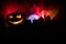 Horror view of Halloween pumpkin with scary smiling face. Head jack lantern with spooky building
