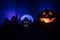 Horror view of Halloween pumpkin with scary smiling face. Head jack lantern with spooky building