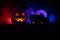 Horror view of Halloween pumpkin with scary smiling face. Head jack lantern with spooky building