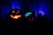 Horror view of Halloween pumpkin with scary smiling face. Head jack lantern with spooky building