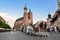 Horse carriage at main square in Krakow in a summer day, Poland. Two Horses In Old-fashioned Coach in front of St. Mary`s Basilic