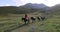 Horse convoy carrying luggage on Caucasus mountain path in Stepantsminda