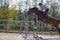 Horse cross country teenage competition jumping tree trunks and jumps over barrels of water and colored bars