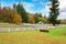 Horse farm with white fence and fall colorful leaves.