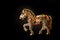 Horse figurine souvenir keychain in gold color richly with bright pebbles shot on a dark background. Background for jewelry and