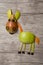 Horse made with apple and pear on wooden background
