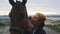 Horse Owner With Her Seal Brown Horse Kissing and Stroking Her Horse - Sunset