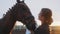 Horse Owner Kissing and Petting Her Horse Showing Affection For Horse Golden Hour