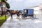 A horse pulling cart of amish people parks at a parking lot