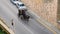 A horse pulls a cart along an asphalt street past cars. City environment, view from above, conflict of times, middle