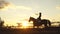 Horse rider at sunset. Young jockey brave girl riding horse jumping
