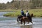 Horse riders crossing a river in Wales