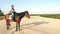 Horse riding. Equitation. horse rider shadow. horsewoman is riding a horse on sandy ground, at sunset, with a large