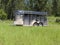 Horse trailer in tall green grass