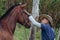 Horse trainer gently stroking horse`s head