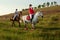 Horseback riders. Two attractive women ride horses on a green meadow