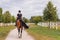 Horseback riding along the trail between wood fences and fields