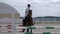 Horsegirl riding brown horse jumping over obstacles in outdoors parkour arena