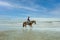 Horseman in cowboy dress are jojjing on sandy beach at Khao Takiab Hua Hin in Thailand