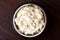 Horseradish sauce in rustic pottery bowl from above on dark wood