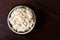 Horseradish sauce in rustic pottery bowl from above on dark wood