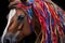 horses mane being braided with colorful ribbons