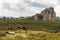 Horses pasturing in the plateau of Argimusco, in Sicily, with a natural megalith in the background