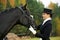 Horsewoman jockey in uniform with horse