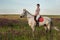 Horsewoman jockey in uniform riding horse outdoors