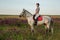 Horsewoman jockey in uniform riding horse outdoors