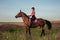 Horsewoman jockey in uniform riding horse outdoors