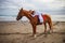 Horsewoman lays down on the withers of the horse. Caucasian woman in white dress riding horse on the beach. Copy space. Sunset