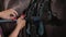 Horsewoman is saddling stallion, fixing saddle on animal body, closeup