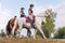 Horsewomen riding horses at the equestrian center on a summer day