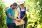 Horticulturist couple harvesting fresh tomatoes and putting on a basket from the garden.