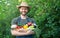 horticulturist in straw hat hold fresh ripe vegetables