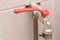 A hose plug quarter turn lever type ball valve water tap with red handle.