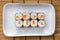 Hosomaki thin rolls, simple rolls, small rolls, with salmon. top view on a white plate. Syake Maki Classic roll with fresh salmon