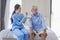 Hospice nurse is feeding porridge food to Caucasian man at pension retirement center for home care rehabilitation and post