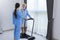 Hospice nurse is supporting Caucasian man to walk using treadmill in pension retirement center for home care rehabilitation and
