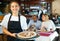 Hospitable latin american waitress meeting guests in pizzeria