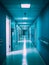 A hospital hallway with blue walls and metal railings. A hospital hallway with vibrant blue lighting