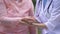 Hospital nurse measuring aged patient pulse by hand, health checkup, clinic