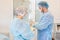 Hospital. Surgeon operates in the operating room. Profile view of a medical assistant helping a surgeon put on his