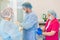 Hospital. Surgeon operates in the operating room. Profile view of a medical assistant helping a surgeon put on his