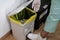 Hospital worker discarding infectious medical waste into disposal container bin. Close up of biohazard contaminated