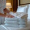 Hospitality finesse Maid carefully arranges towel, perfecting the hotel room