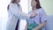 Hospitalized Asian woman lying in bed while doctor checking his pulse. Young Asian doctor woman physician examining women patient