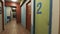 hostel long hallway with storage and many dormitory rooms with numbers